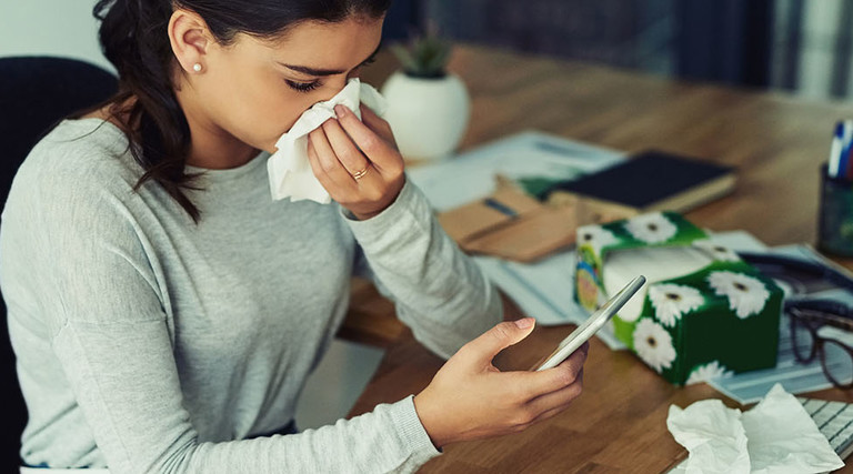 Girl sick with flu on her smartphone