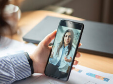 patient holds phone and speaks to doctor during telehealth appointment