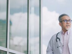 doctor in front of clouds and reflective building